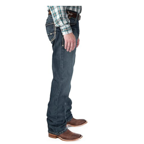 A man wearing the Men's Ariat M4 Boundary Gulch Jeans 10012136 from the Men's Ariat M4 Boundary Gulch collection and a plaid shirt.