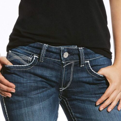 A woman wearing jeans with her hands in her pockets.