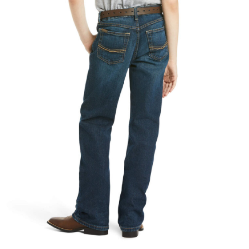 The back view of a boy wearing Boy's Ariat Jeans B4 Relaxed Boot Cut 10027675 and a cowboy hat.