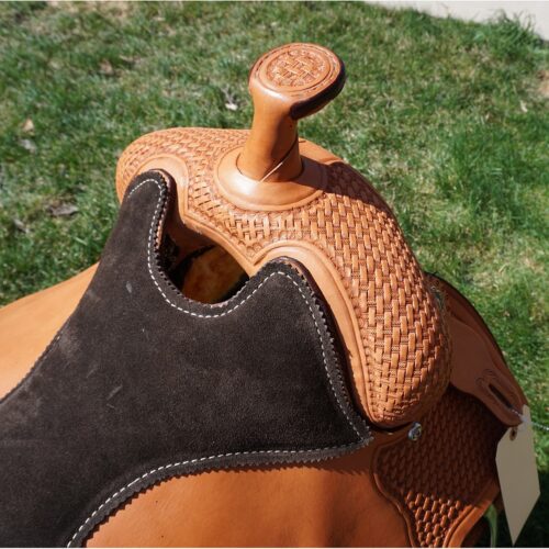 A close up of a brown and black 16 1/2" Custom Reiner Saddle.