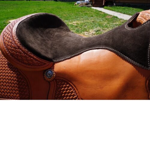 A close up of the 16 1/2" Custom Reiner Saddle on a grassy yard.