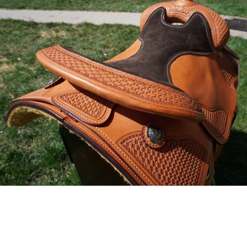 A 16 1/2" custom reiner saddle with a brown and black leather seat.