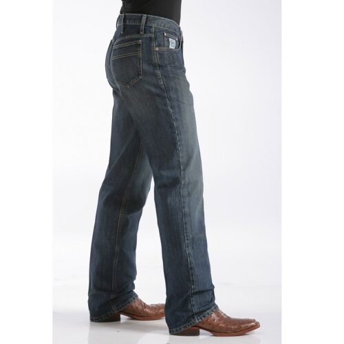 A man wearing the Men's Cinch White Label Dark Stone Wash MB92834013 collection jeans and a cowboy hat.