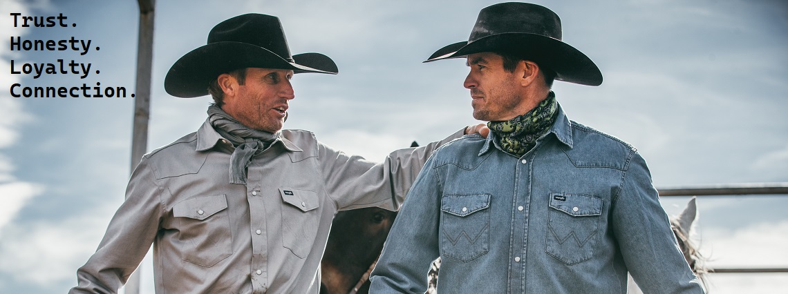 Two cowboys donning Western apparel, wearing cowboy hats and cowboy shirts.