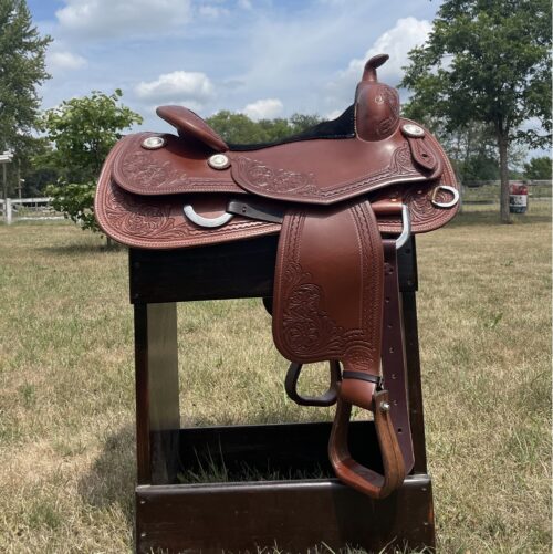 Bob Avila 16.5" Reining Saddle sitting on a stand in a field.