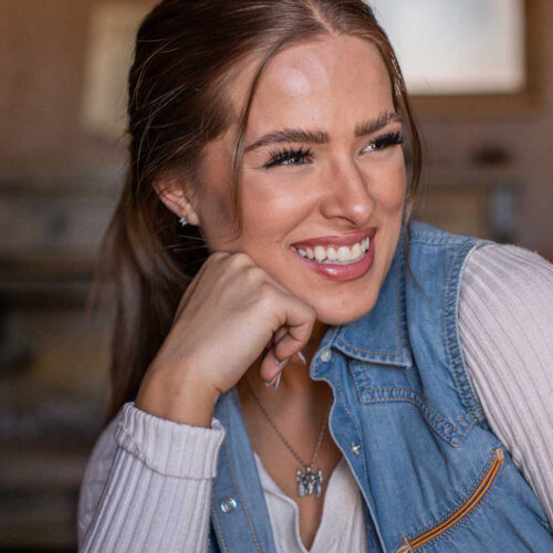 Woman smiling with hand on chin.