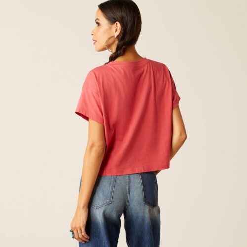 Woman wearing a red cropped t-shirt and jeans.